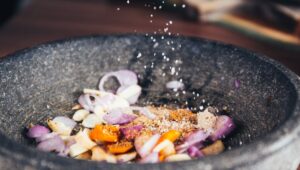 person pouring salt in bowl