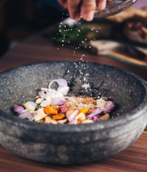 person pouring salt in bowl