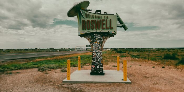 welcome signage under white clouds