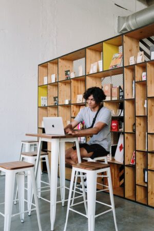 man in white crew neck t shirt sitting on white wooden chair