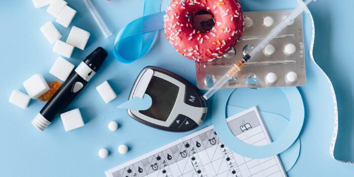 blood sugar meter and medication on the blue background